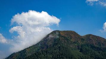 view of mountains with white clouds in the sky photo