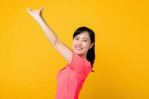 Portrait beautiful young asian sports fitness woman happy smile wearing pink sportswear posing exercise training workout isolated on yellow studio background. wellbeing and healthy lifestyle concept. photo