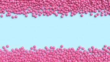 Double border of pink coated chocolate candies on blue pastel background photo