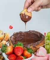 Chocolate fondue cake with strawberries, bananas and marshmallows photo