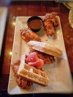 Fried waffles with honey and ice cream on a wooden table photo