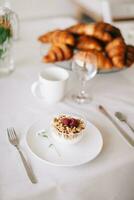 desayuno con Granola, yogur y croissants en el mesa foto
