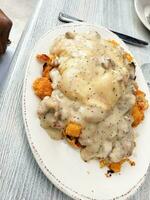 Creamy chicken fillet with mushroom sauce on a white plate photo