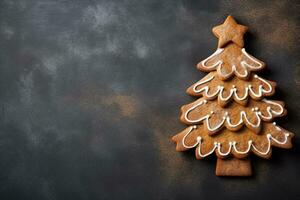 pan de jengibre Navidad árbol hecho en casa Galleta en oscuro fondo, Copiar espacio. invierno Días festivos pasteles ai generado. foto