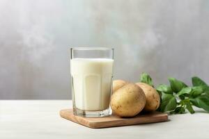 Glass of potato milk and raw potatoes with copy space. Alternative plant based milk. Healthy food concept. AI generated. photo