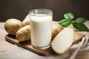 Glass of potato milk and raw potatoes close up. Alternative plant based milk. Vegan, healthy food. AI generated. photo