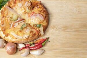 Pizza en de madera tablero con Fresco pimientos y albahaca con ajo en Copiar espacio antecedentes foto