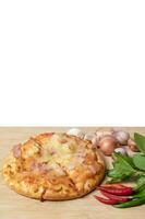 Pizza with fresh chili and garlic along with basil on wooden table photo