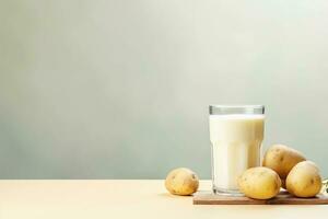 Glass of potato milk and raw potato tubers, copy space. Alternative plant based milk, vegan, healthy food. AI generated. photo