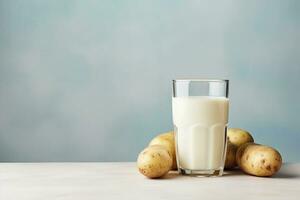 Glass of potato milk and raw potatoes with copy space. Alternative plant based milk. Healthy food concept. AI generated. photo