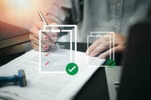 business management with document check list at work place. Man holding pen mark on checklist report virtual screen. photo