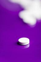 White pills over a solid lilac baclground with optical bokeh effect. photo