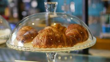 verticaal sho of vers gebakken croissant in een glas transparant houder Bij winkel video