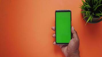 top view of young man hand using smart phone with green screen video