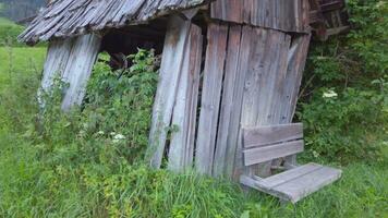 an old wooden shed with a bench sitting in the middle of the field video