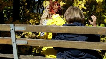 Due bambini seduta su un' panchina nel il parco video