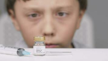 un chico es mirando a un frasco de vacuna video