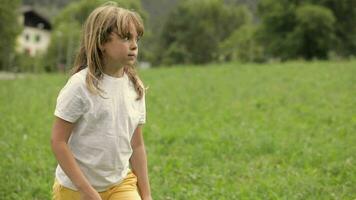 a young girl is standing in a field with a soccer ball video