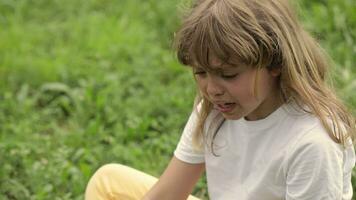 a young girl sitting in the grass with her hands on her knees video