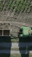 an aerial view of a tractor and trailer loading a truck with potatoes video