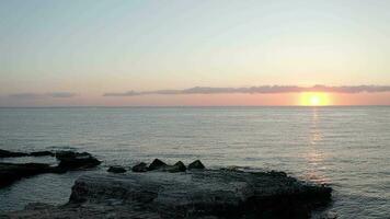 the sun sets over the ocean and rocks video