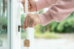 Landlord key for unlocking house is plugged into the door. Second hand house for rent and sale. Owner use hand unlock door mortgage for new home, buy, sell, renovate, investment, owner, estate photo