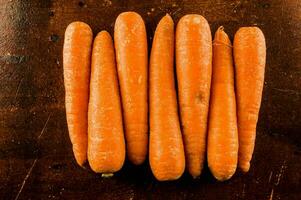 a group of carrots on a wooden surface photo