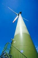 a wind turbine with a green tower and a ladder photo