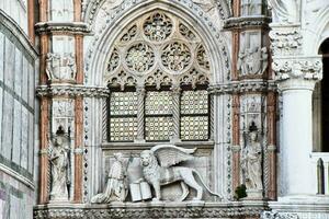 the lion statue is in front of a building with ornate decorations photo