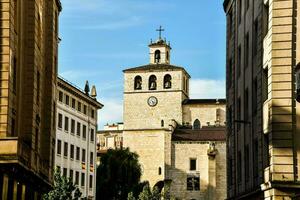 a church tower is seen in the middle of a city street photo