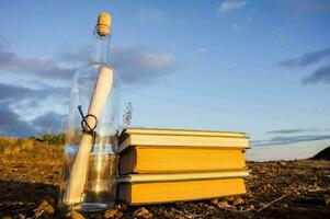 mensaje en un botella y libros en el playa foto