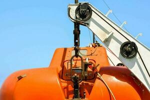 a large orange boat with a crane attached to it photo