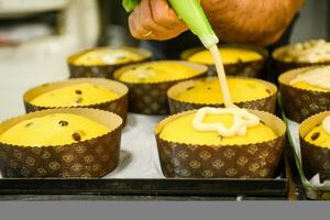 chef producing panettone, while lievitate, adding almond sugar topping to raw sweet bread. photo