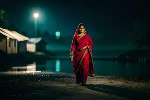 un mujer en un rojo sari caminando a lo largo el apuntalar a noche. generado por ai foto