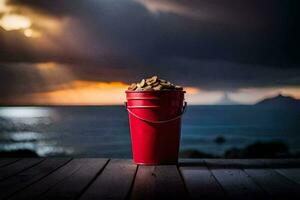 a red bucket with peanuts on a wooden table in front of the ocean. AI-Generated photo