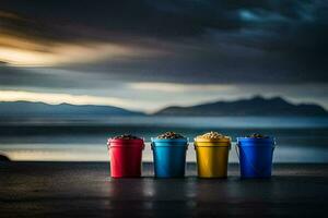 four colorful cups sit on a table with a mountain in the background. AI-Generated photo