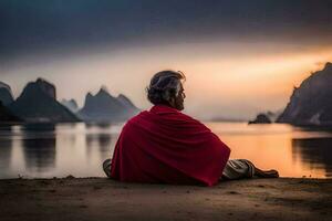 un hombre sentado en el playa a puesta de sol. generado por ai foto