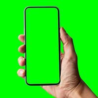 hand shows mobile smartphone with green screen in vertical position isolated on green background. Mock up mobile photo