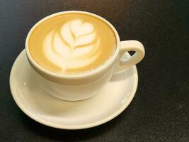 Coffee in a cup on a black background. Brewed coffee in a porcelain cup. Coffee advertisement photo