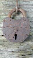 Old lock. Old padlock on a wooden background. Vintage photo