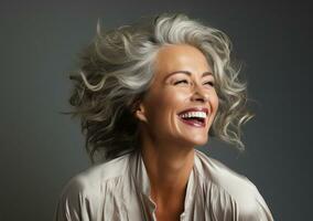 a closeup photo portrait of a beautiful elderly senior old mature female model woman grey hair laughing and smiling. morning skin care routine cosmetics on black background.