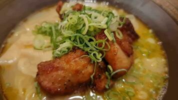 A bowl of halal ramen that has just been served, the smoke is rising and looks very delicious. Typical Japanese ramen with oily sauce, and very delicious spiced chicken pieces, with spring onions video