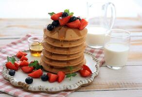 Pancakes with Berries and Maple Syrup for Breakfast photo
