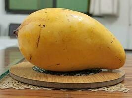 Ripe yellow papaya on a cutting board on a wooden table photo