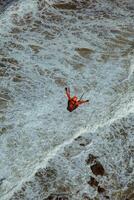 Aerial view of a man doing kitesurfing in the sea photo