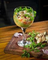 Fresco vegetal ensalada en un vaso en un de madera tablero con perejil foto