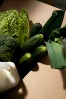 Close up of fresh green vegetables in box on wooden table, healthy food concept photo