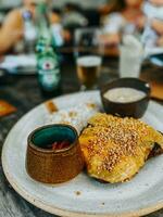 Crispy bread with cheese and sesame seeds on a plate. photo