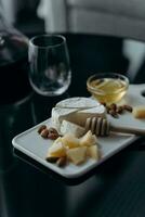 Cheese plate with camembert, nuts and honey on dark background photo