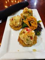 Fried fish cakes on a white plate in a restaurant, Thailand. photo